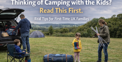 Family of four arriving at a UK campsite unloading their car and setting up a tent under cloudy skies, with overlaid text promoting first-time family camping advice for UK parents.