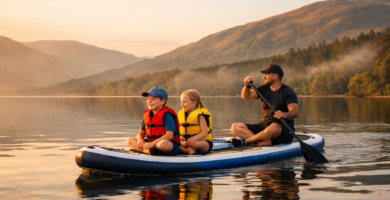 family-paddle-boarding-scottish-loch.jpg Alt text: Family paddle boarding on a calm Scottish loch with children wearing buoyancy aids at golden hour